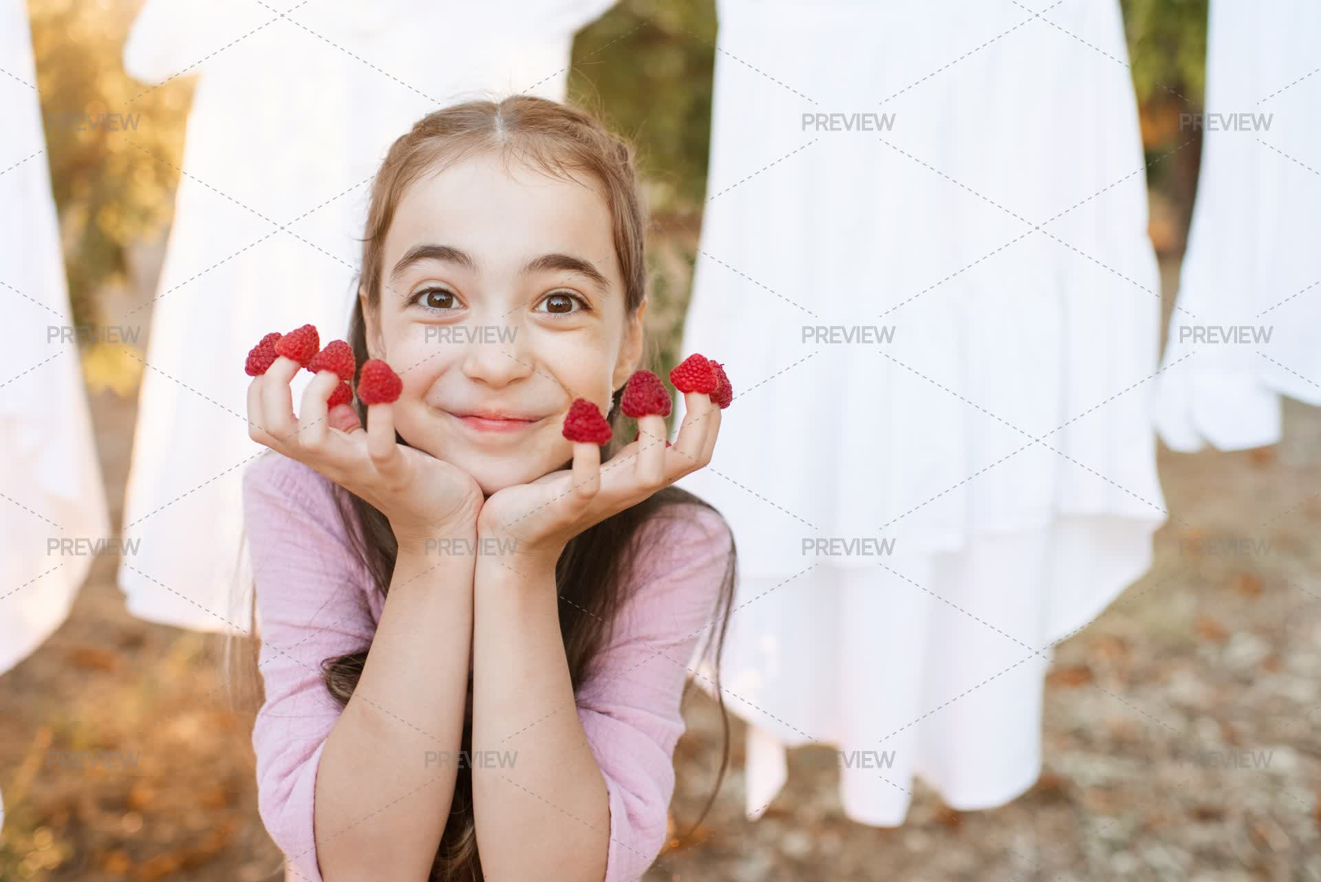 Smiling Kid Girl Eating Raspberry - Stock Photos | Motion Array