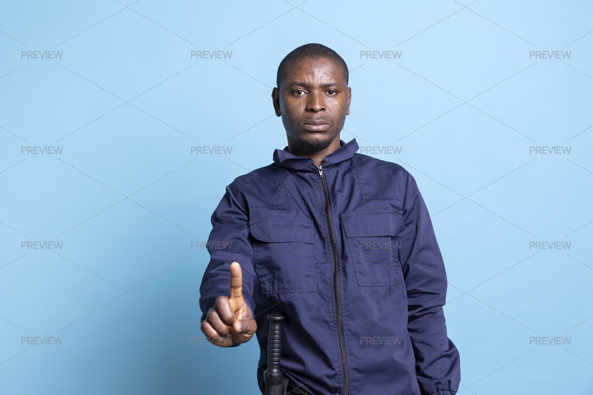 Security Guard Poses With A Finger Up In Studio - Stock Photos | Motion ...