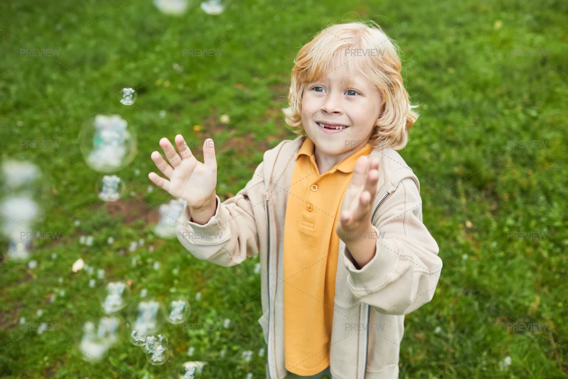 Smiling Is Catching Smiling Boy Catching Bubbles - Stock Photos | Motion Array