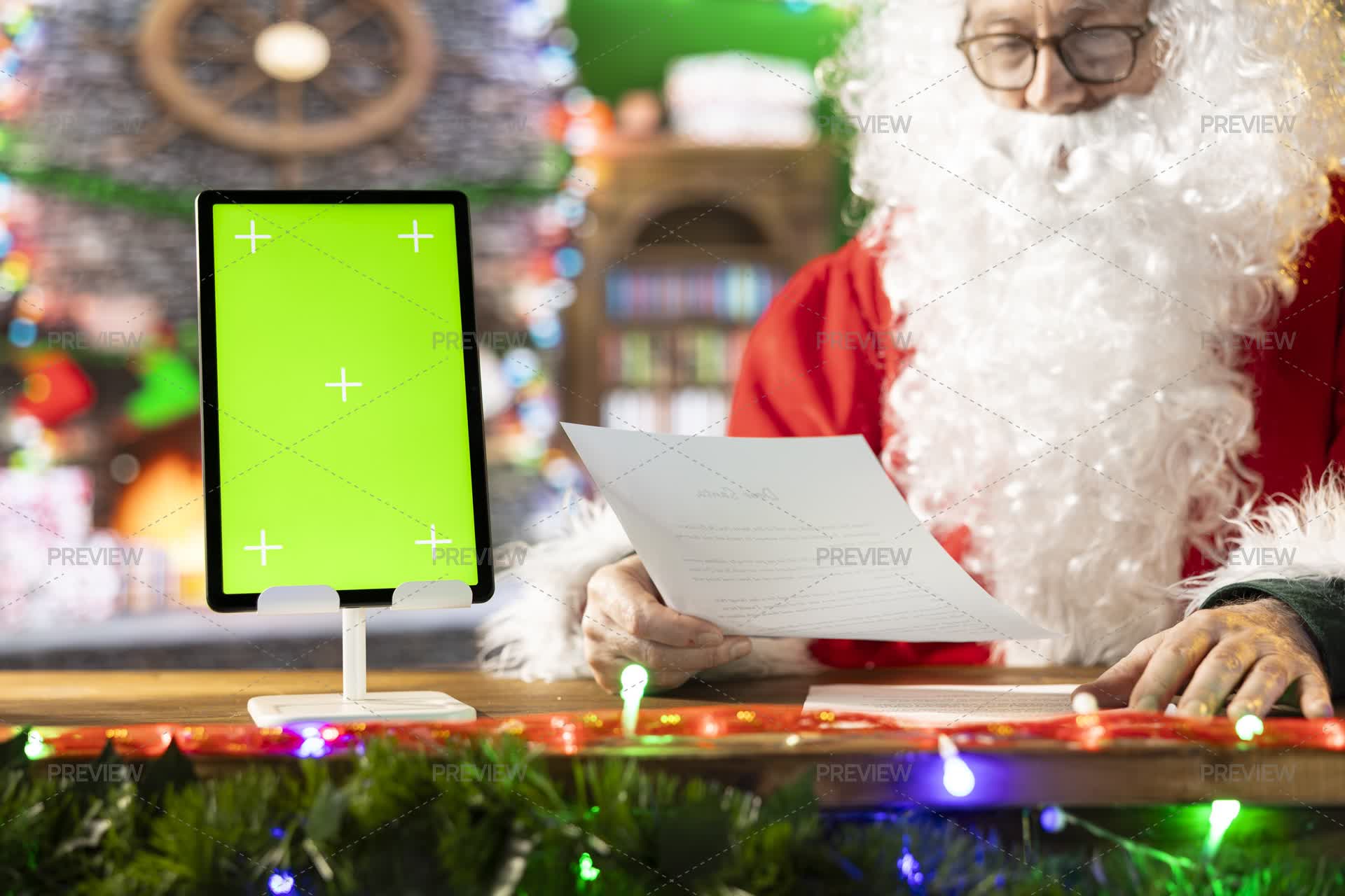 Santa Reading Wishes For Toys And Gifts Next To Green Screen - Stock ...