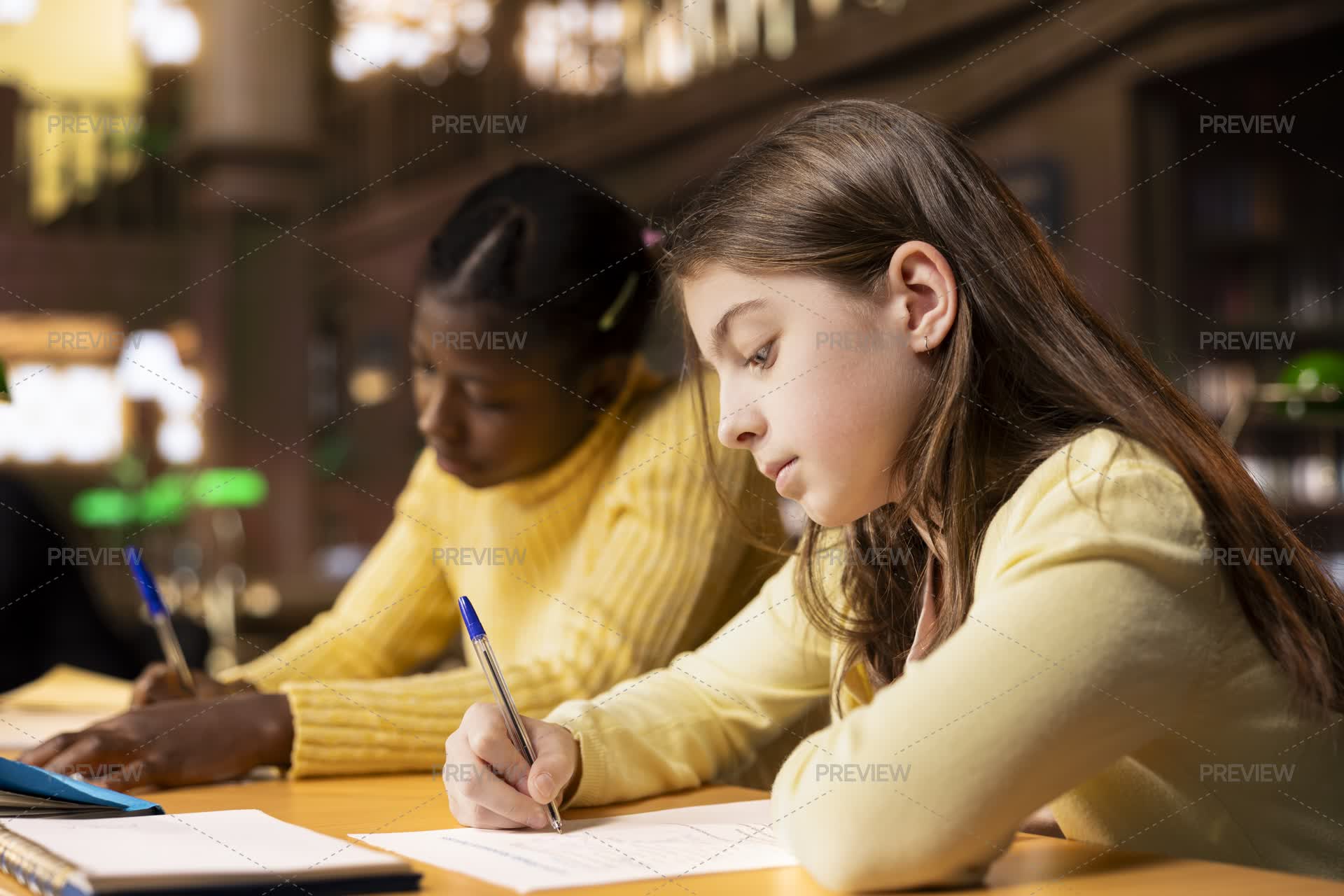 Multiethnic Students Doing Their Homework At A Library Desk After ...