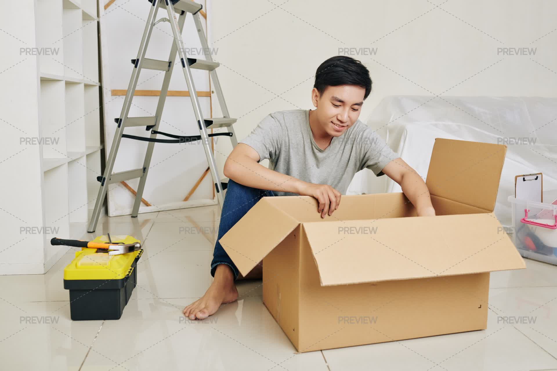 Asian Man Unpacking Tools - Stock Photos | Motion Array